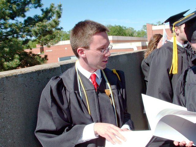Before baccalaureate, outside the Union--Benjamin Hampton peruses the bulletin for the baccalaureate.