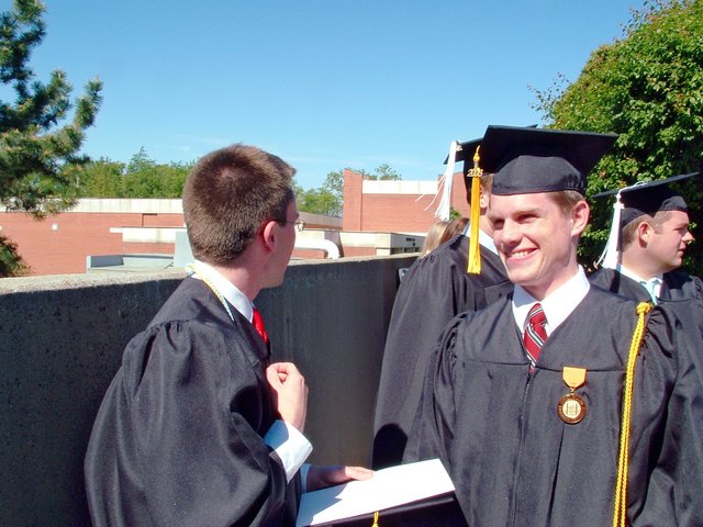 Before baccalaureate, outside the Union--Matthew Schaefer snickers while Benjamin Hampton, his hand up at his collar, turns from the camera.