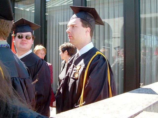 A stately-looking Carl Bear is profiled in front of the Union before baccalaureate.  Matthew Fry, to one side of Carl, faces the camera.