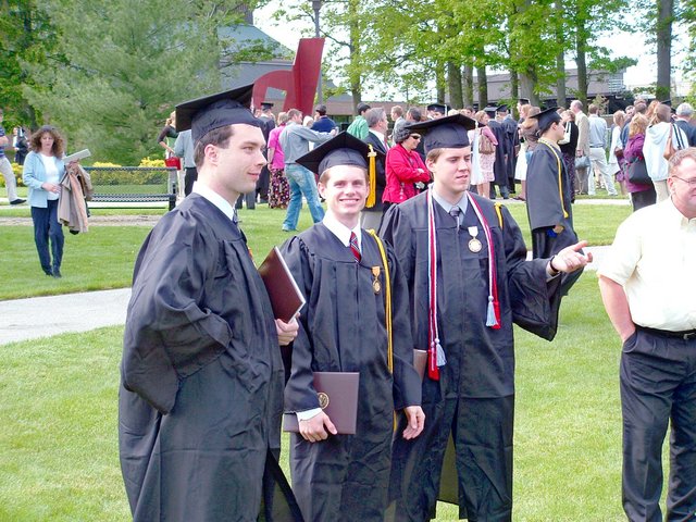 Carl Bear, in profile; Matthew Schaefer, facing the camera; and John Unrath, in profile, standing together after commencement to the east side of the Athletics and Recreation Center.