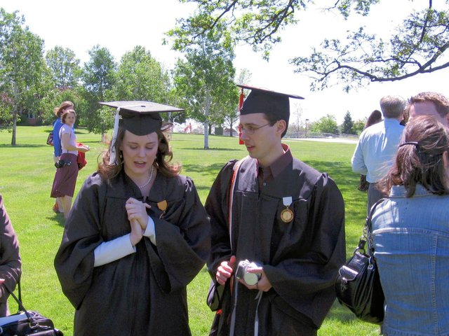 After baccalaureate and near Merlin: Caleb Sancken, viewed in profile, listens to Kristin Thomas, viewed with her face tilted slightly down.  (From Gregory Sancken)