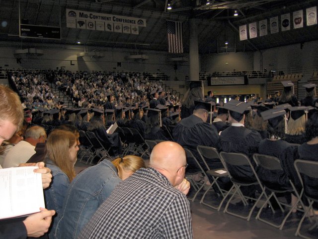 Those with a Christ College designation stand during commencement to be recognized.  Amy Kalchbrenner, Kimberly Christman, Caleb Sancken, Jason Hallman, Drew Korshavn, and others are visible to varying degrees. (From Gregory Sancken)